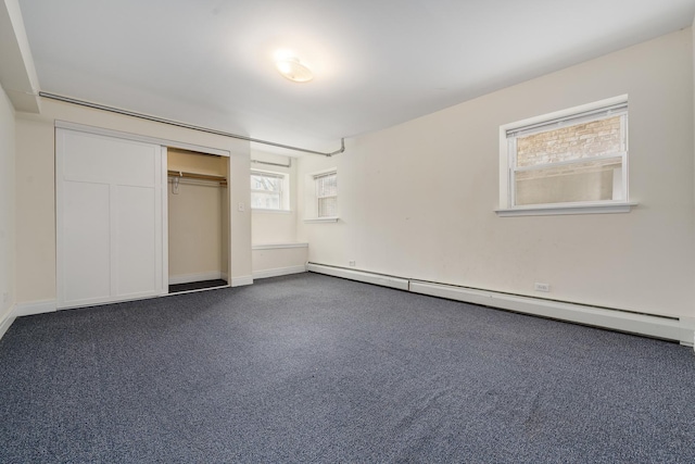 unfurnished bedroom featuring a baseboard radiator, carpet floors, and a closet