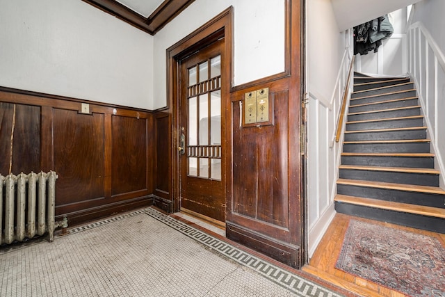 foyer with crown molding and radiator