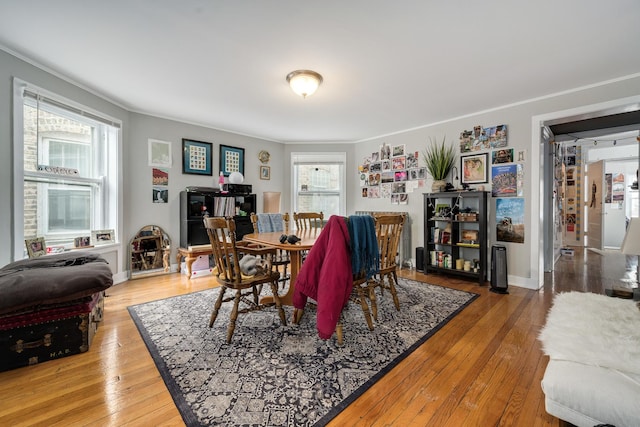 dining room with ornamental molding, a healthy amount of sunlight, and hardwood / wood-style floors