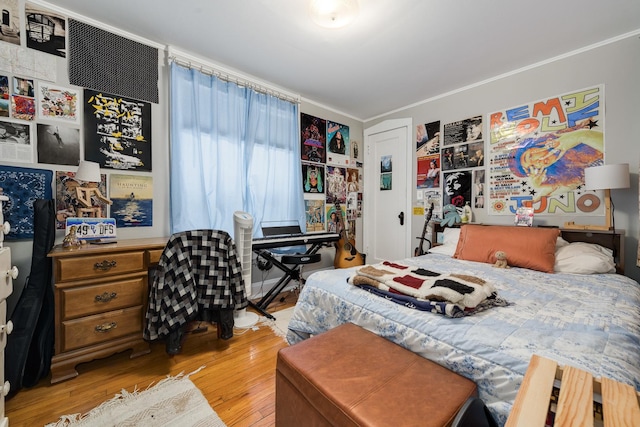 bedroom featuring ornamental molding and light wood-type flooring