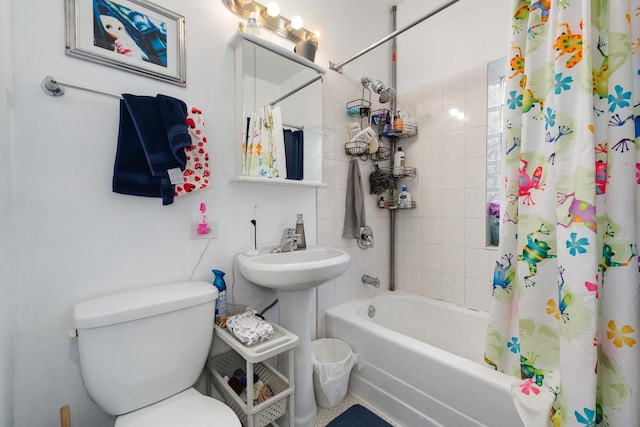 full bathroom featuring sink, shower / bathtub combination with curtain, and toilet