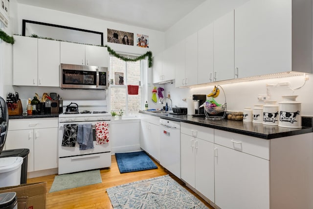 kitchen featuring sink, white appliances, white cabinets, and light wood-type flooring