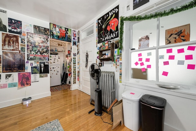 interior space with radiator and hardwood / wood-style floors