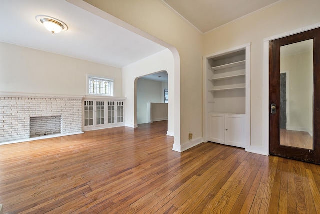 unfurnished living room featuring hardwood / wood-style floors and built in features