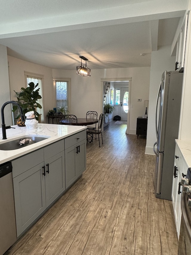 kitchen with gray cabinets, light hardwood / wood-style flooring, decorative light fixtures, sink, and appliances with stainless steel finishes