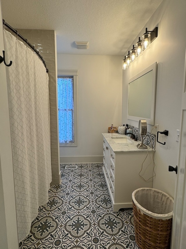 bathroom featuring tile patterned flooring, vanity, curtained shower, and a textured ceiling