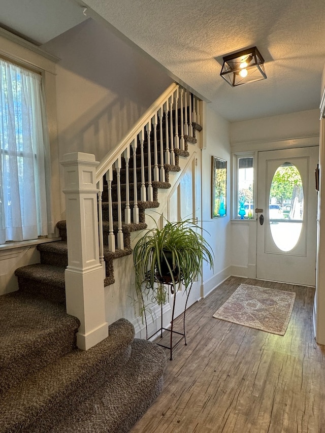 entryway with hardwood / wood-style flooring and a textured ceiling