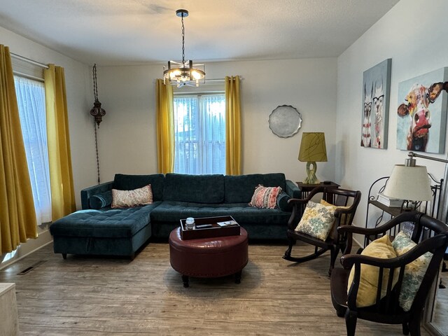 living room featuring wood-type flooring and an inviting chandelier