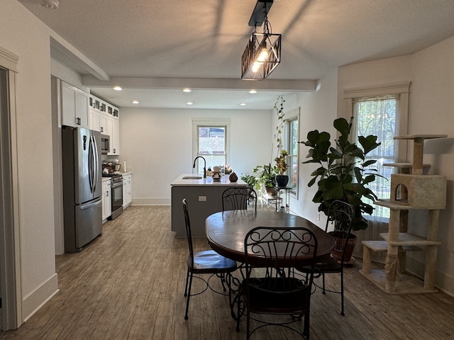 dining room featuring hardwood / wood-style flooring, plenty of natural light, sink, and a textured ceiling