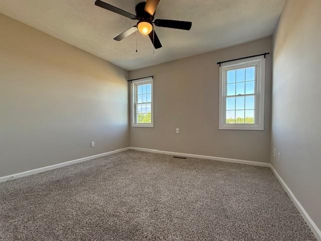 2501 Woodridge Pl, Champaign, IL 61822 - unfurnished room featuring baseboards, a ceiling fan, and carpet flooring
