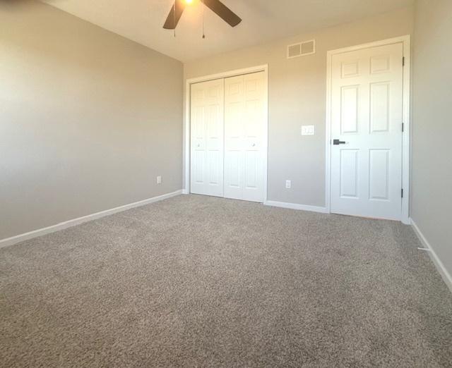 2501 Woodridge Pl, Champaign, IL 61822 - unfurnished bedroom featuring baseboards, a closet, and carpet floors