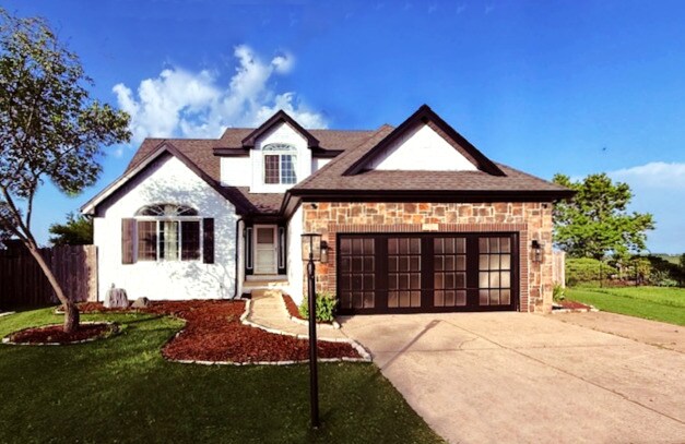 2501 Woodridge Pl, Champaign, IL 61822 - view of front of property with an attached garage, concrete driveway, and stone siding