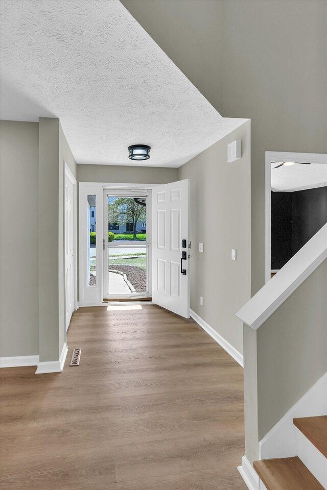 2501 Woodridge Pl, Champaign, IL 61822 - foyer entrance featuring wood finished floors, baseboards, and a textured ceiling