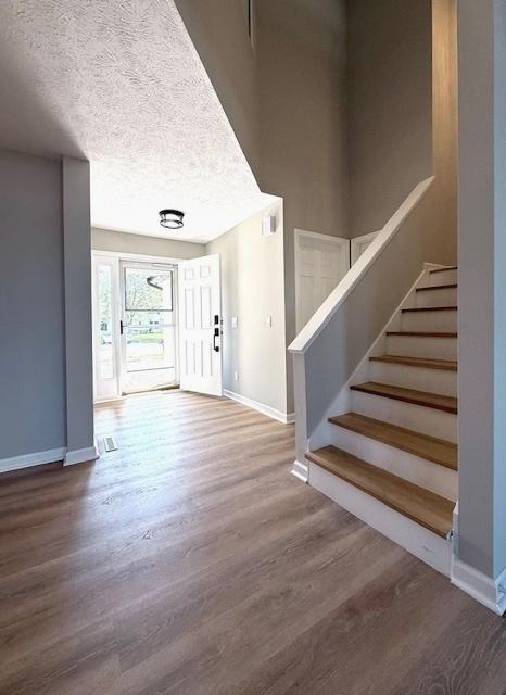 2501 Woodridge Pl, Champaign, IL 61822 - foyer entrance featuring baseboards, wood finished floors, stairway, and a textured ceiling