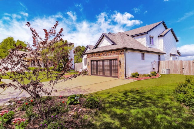2501 Woodridge Pl, Champaign, IL 61822 - view of side of home featuring a garage, concrete driveway, stone siding, roof with shingles, and central AC unit