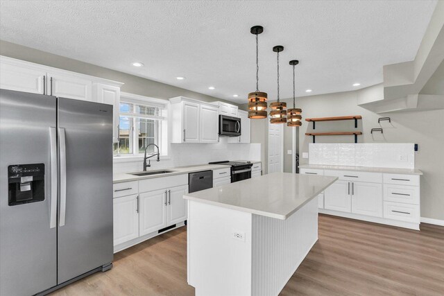 2501 Woodridge Pl, Champaign, IL 61822 - kitchen with stainless steel appliances, a sink, open shelves, light wood-style floors, and a textured ceiling