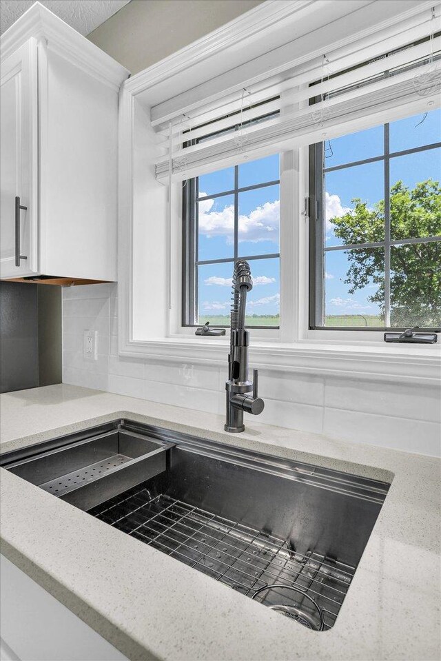 2501 Woodridge Pl, Champaign, IL 61822 - kitchen view of a sink, tasteful backsplash, and white cabinetry