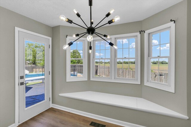 2501 Woodridge Pl, Champaign, IL 61822 - unfurnished dining area with a chandelier, wood finished floors, baseboards, and plenty of natural light
