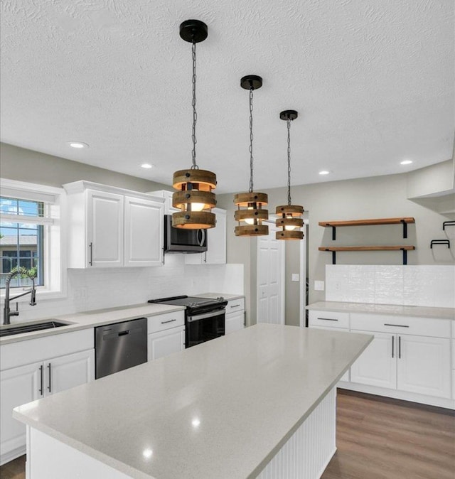 2501 Woodridge Pl, Champaign, IL 61822 - kitchen with appliances with stainless steel finishes, a sink, open shelves, wood finished floors, and a textured ceiling