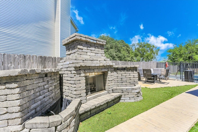 2501 Woodridge Pl, Champaign, IL 61822 - fenced backyard featuring an outdoor stone fireplace, a patio, central AC, and outdoor dining space