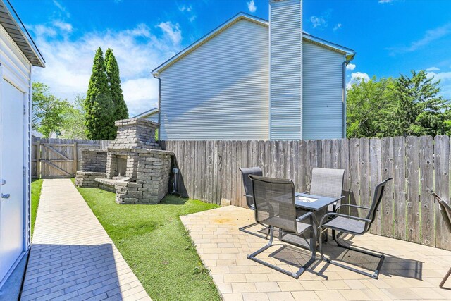 2501 Woodridge Pl, Champaign, IL 61822 - fenced backyard with a patio, an outdoor stone fireplace, and outdoor dining space