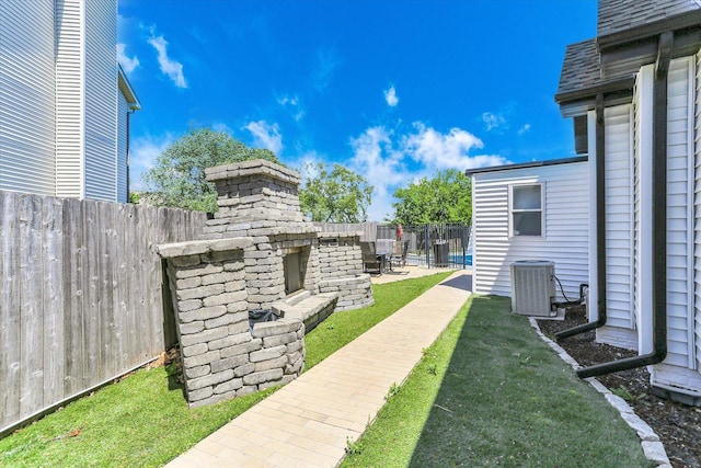 2501 Woodridge Pl, Champaign, IL 61822 - fenced backyard featuring exterior fireplace, central air condition unit, and a patio