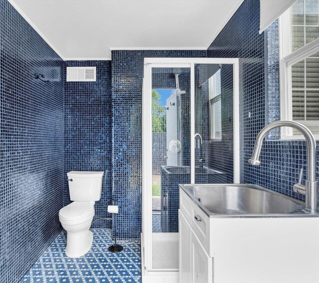 2501 Woodridge Pl, Champaign, IL 61822 - bathroom with tile walls, toilet, healthy amount of natural light, a stall shower, and vanity