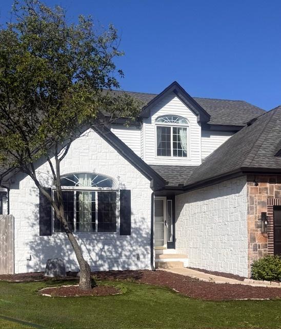 2501 Woodridge Pl, Champaign, IL 61822 - view of front of property featuring a shingled roof, a front lawn, and stone siding
