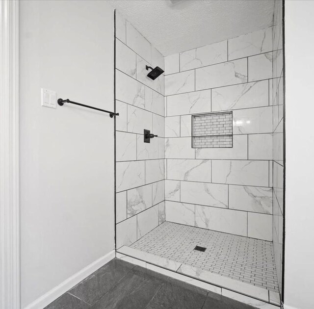 2501 Woodridge Pl, Champaign, IL 61822 - bathroom with baseboards, tiled shower, and a textured ceiling