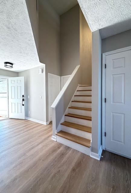 2501 Woodridge Pl, Champaign, IL 61822 - stairway featuring wood finished floors, a textured ceiling, and baseboards