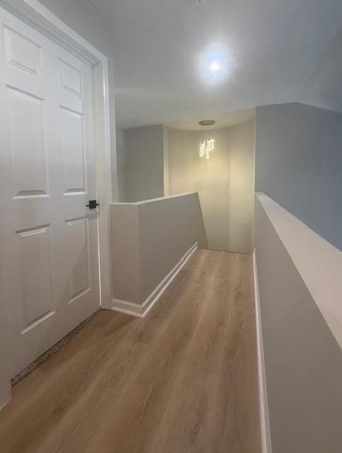 2501 Woodridge Pl, Champaign, IL 61822 - hallway with wood finished floors and an upstairs landing