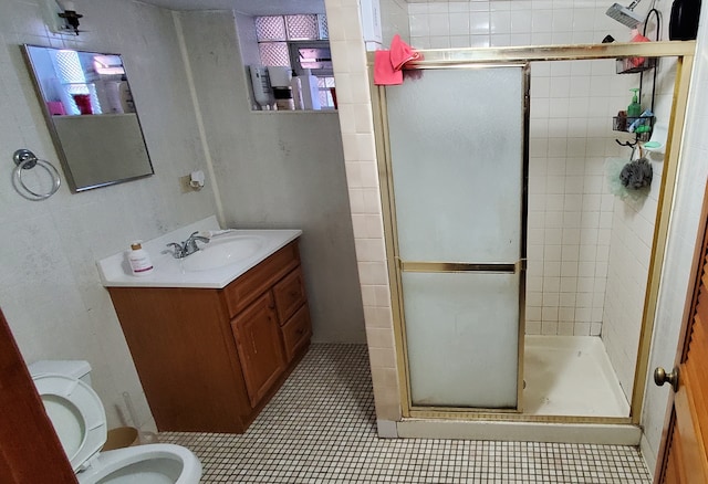 bathroom with vanity, a shower with shower door, toilet, and tile patterned floors