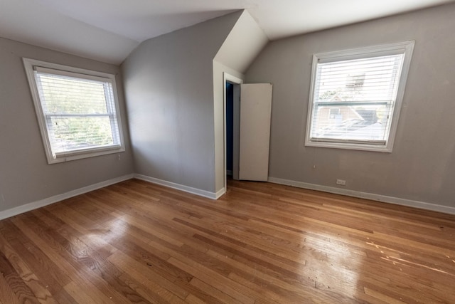 bonus room with light hardwood / wood-style floors, vaulted ceiling, and a wealth of natural light