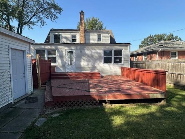 rear view of property with a lawn and a deck