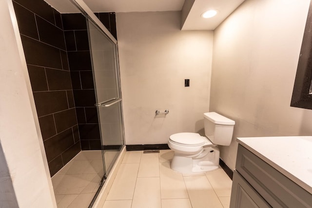 bathroom with tile patterned flooring, vanity, a shower with door, and toilet