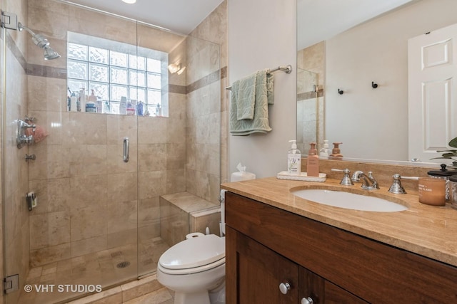 bathroom featuring toilet, vanity, and an enclosed shower