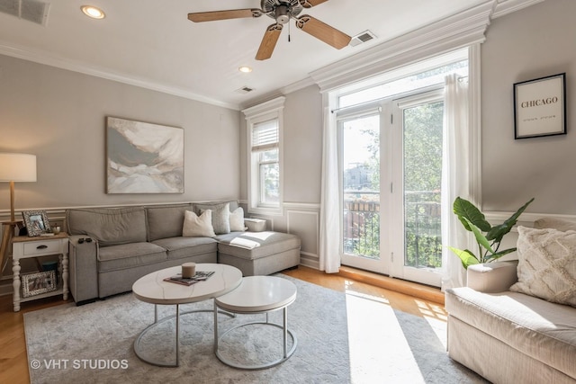 living room with ceiling fan, crown molding, and light hardwood / wood-style floors