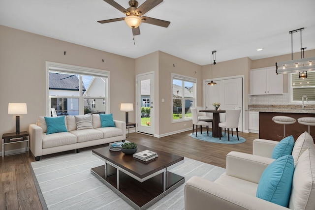 living room with light hardwood / wood-style floors, sink, and ceiling fan