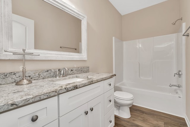 full bathroom with hardwood / wood-style flooring, vanity, toilet, and shower / bathing tub combination