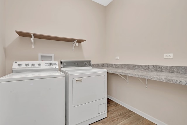 laundry room featuring independent washer and dryer and light hardwood / wood-style flooring