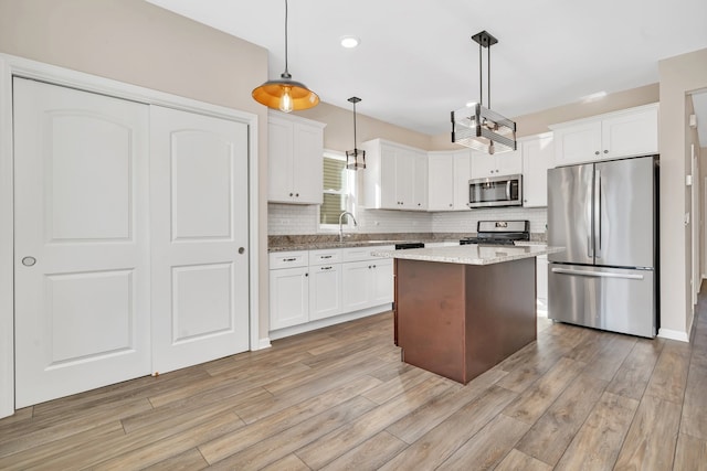 kitchen featuring a center island, hanging light fixtures, white cabinetry, and stainless steel appliances