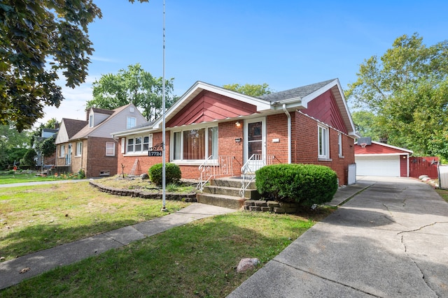 view of front of property with a front yard, a garage, and an outbuilding