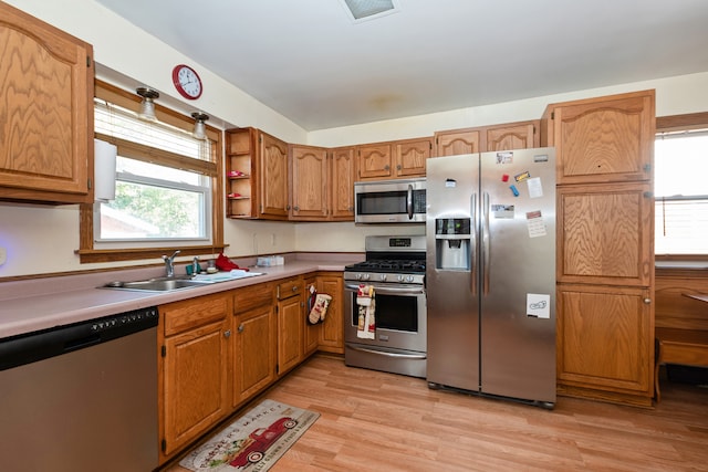 kitchen featuring stainless steel appliances, sink, and light hardwood / wood-style flooring