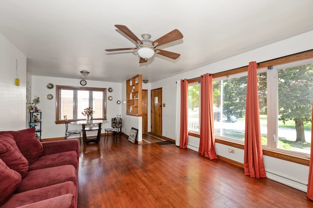 living room with ceiling fan, a baseboard radiator, dark wood-type flooring, and a wealth of natural light