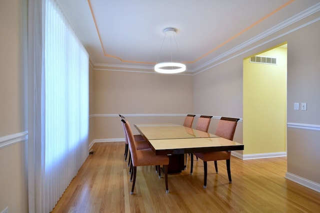 dining area featuring light wood-type flooring and ornamental molding