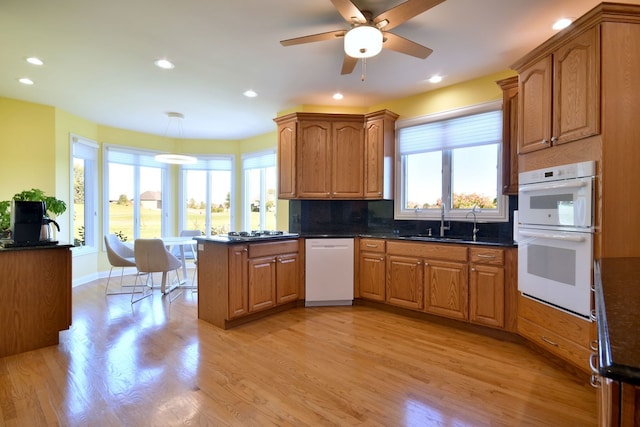 kitchen featuring ceiling fan, sink, tasteful backsplash, white appliances, and light wood-type flooring