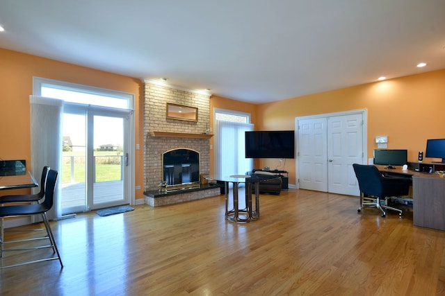 office space featuring a brick fireplace, plenty of natural light, and wood-type flooring