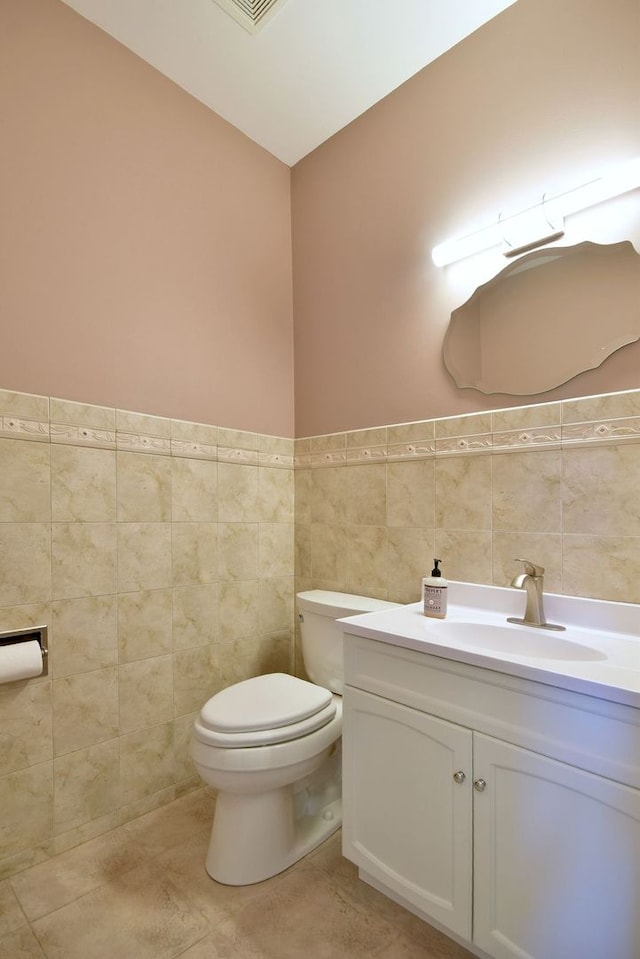 bathroom with tile walls, tile patterned floors, vanity, and toilet