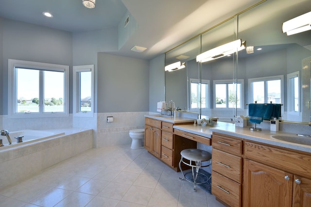 bathroom with a wealth of natural light, a relaxing tiled tub, vanity, and toilet