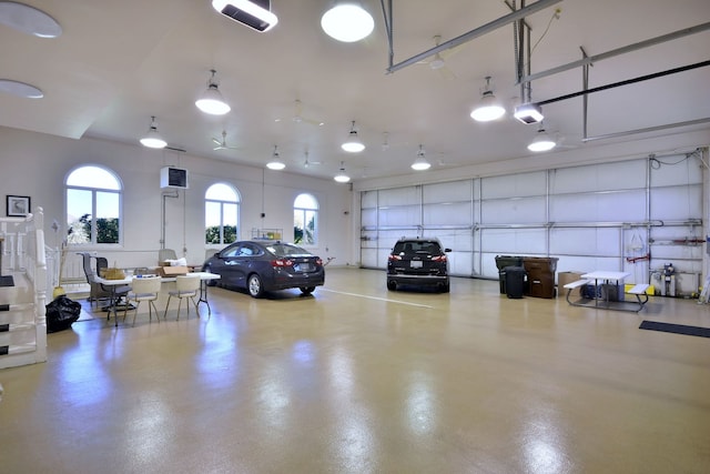 garage featuring a garage door opener and a wall mounted AC